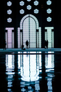 Reflection of silhouette people in mosque