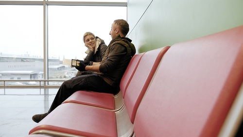 Friends talking while sitting on chairs