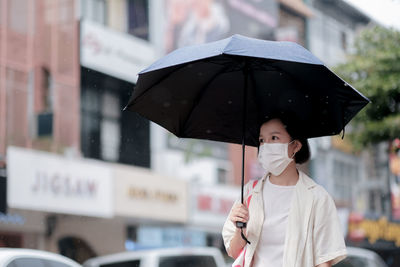 Man holding umbrella in rain