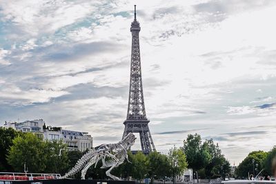 Tower in city against cloudy sky