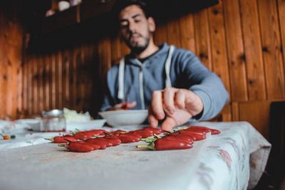 Man having red chili pepper at table in restaurant