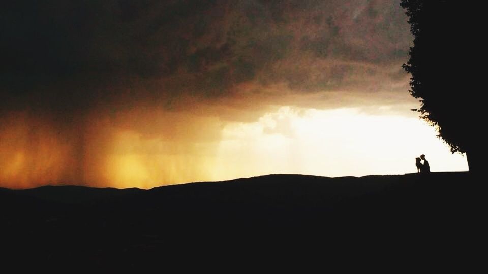 SILHOUETTE PEOPLE ON MOUNTAIN AGAINST SKY AT SUNSET