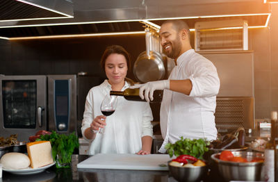 Young man and woman standing in kitchen