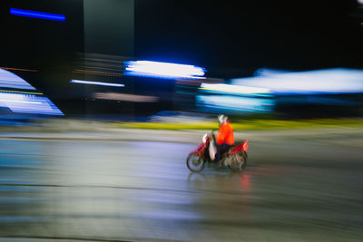 Man riding motorcycle on road at night