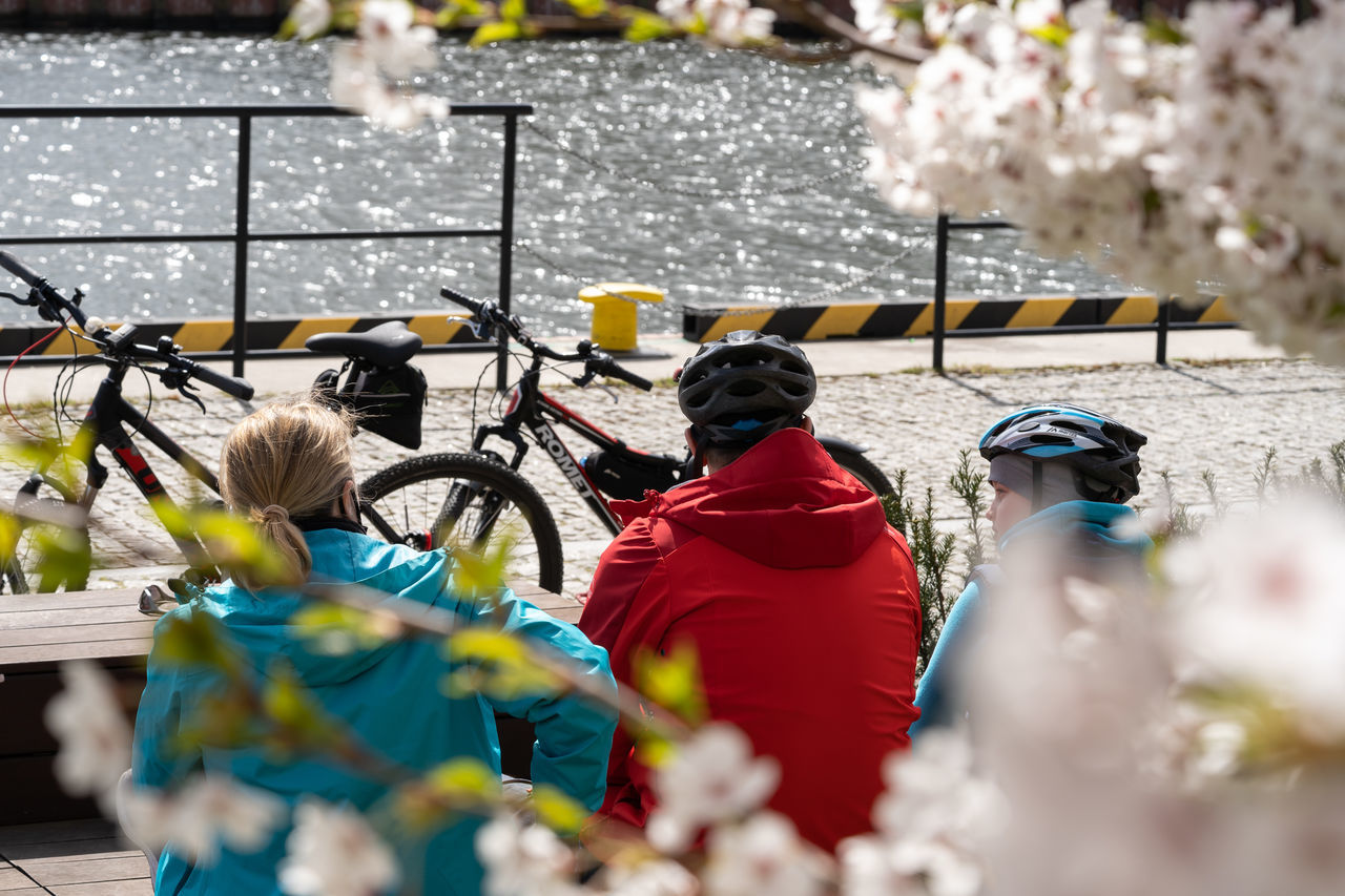 REAR VIEW OF PEOPLE WITH BICYCLE STANDING ON SNOW