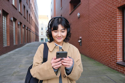 Young woman using mobile phone in city