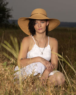 Portrait of woman wearing hat standing on field