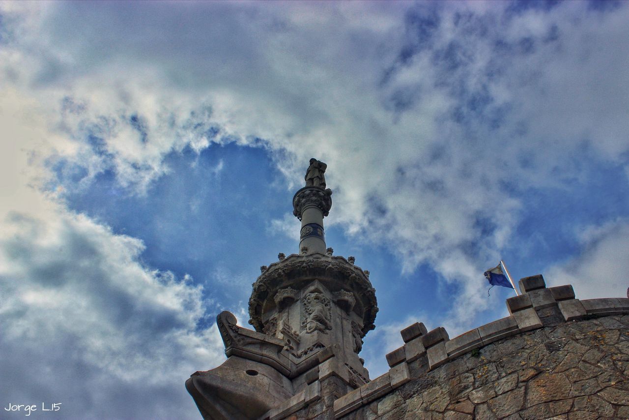 low angle view, statue, sky, sculpture, human representation, cloud - sky, architecture, art and craft, built structure, art, building exterior, cloudy, creativity, cloud, history, famous place, blue, travel destinations, outdoors