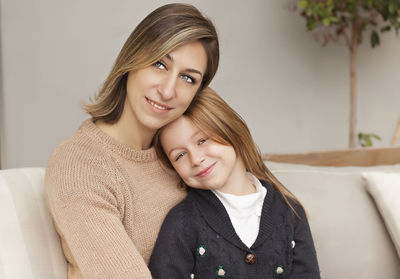 Portrait of a smiling young woman with daughter