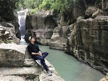 Full length of man against waterfall in forest