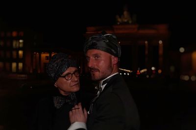 Close-up of couple with illuminated lighting equipment at night