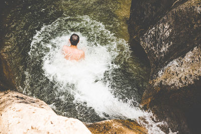 High angle view of teenage boy swimming in river