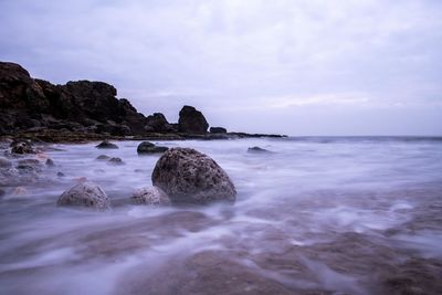 Rocks in sea against sky