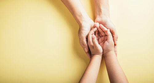 Cropped hand of woman against wall