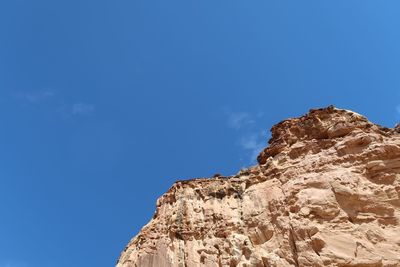 Low angle view of rock formations against blue sky