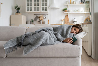 Young woman sitting on sofa at home