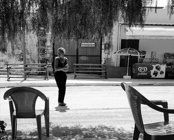 Full length of woman standing on chair against trees