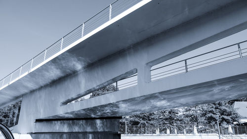 Low angle view of building by bridge against sky