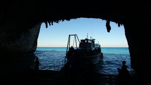 Silhouette boat on sea against clear sky