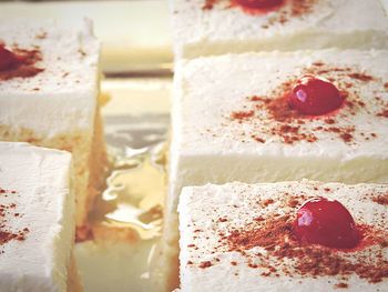 Close-up of cherry on fresh tres leches cake