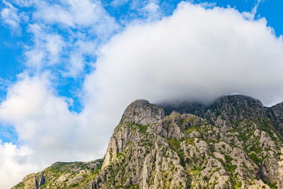 Low angle view of mountain against cloudy sky