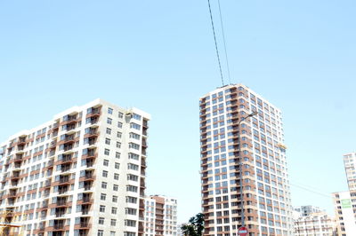 Low angle view of modern buildings against clear blue sky