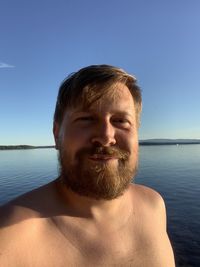 Portrait of young man against sea against sky