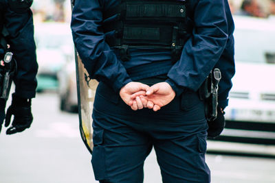 Midsection of man wearing mask standing in city