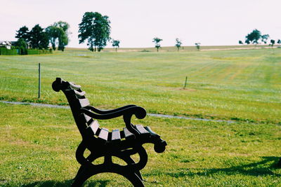 Empty park bench on field