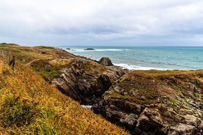 Scenic view of rocks on beach against sky