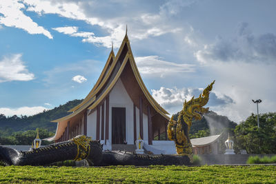 Statue of temple against building and sky