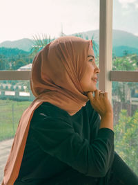 Portrait of woman sitting by window