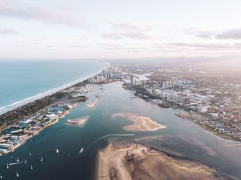 High angle view of cityscape by sea against sky