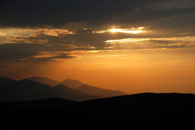 Scenic view of silhouette mountains against sky during sunset