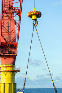 An offshore pedestal crane on board a construction work barge performing a lifting of an anchor 