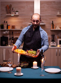 Portrait of senior man preparing food on table