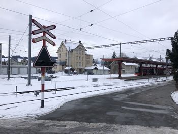 Road by buildings against sky during winter