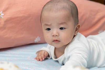 Portrait of cute baby lying on bed