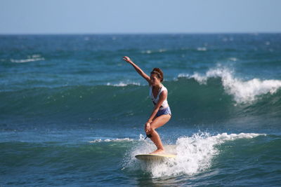 Full length of woman surfing in sea