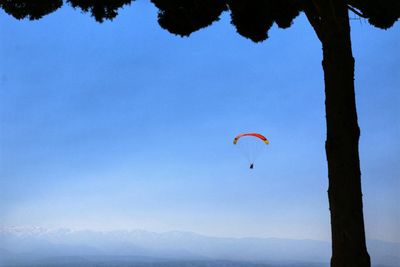 Person paragliding against sky