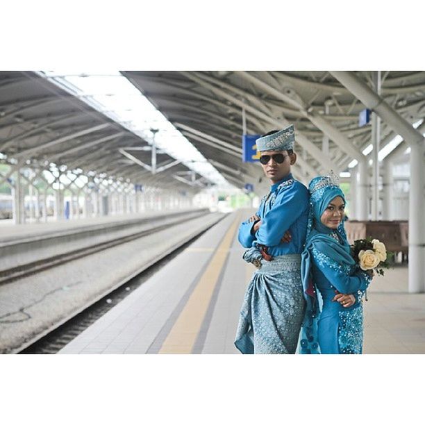 lifestyles, transportation, railroad track, casual clothing, full length, rail transportation, leisure activity, public transportation, men, railroad station platform, railroad station, travel, indoors, rear view, train - vehicle, standing, mode of transport, architecture