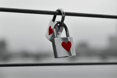 Close-up of padlocks hanging on railing against sky