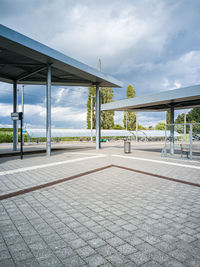 Empty tram stop against sky in city