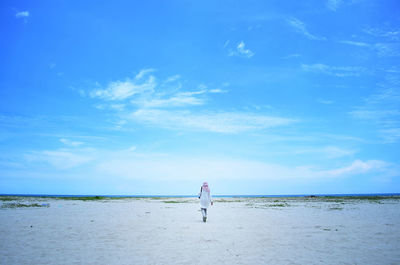 Rear view of woman islamic walking on beach