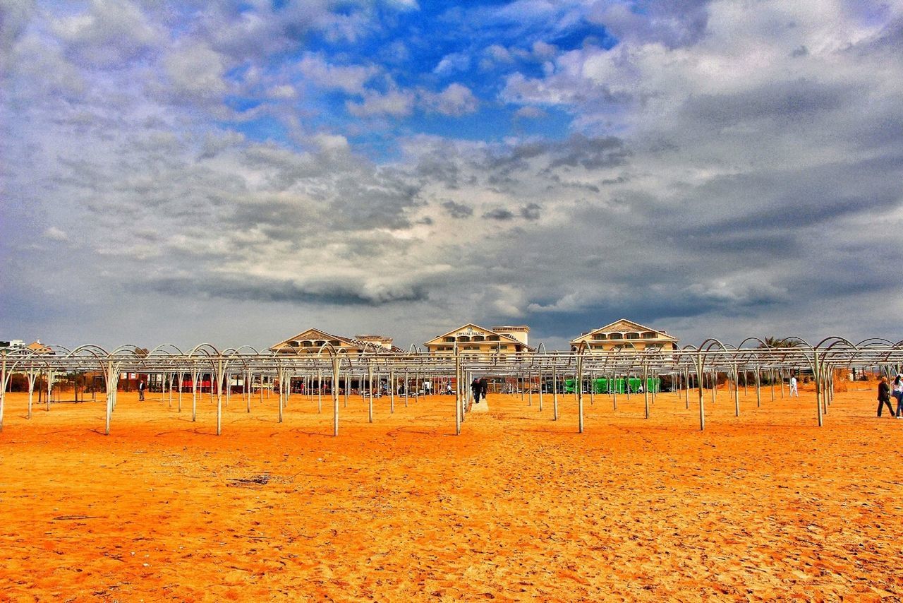 architecture, built structure, sky, cloud - sky, building exterior, beach, cloudy, cloud, famous place, travel destinations, tourism, sand, travel, sea, water, history, outdoors, incidental people, day, vacations