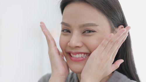 Close-up of young woman against white background