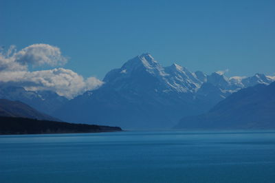 Scenic view of lake and mountains against blue sky