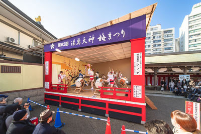 People on street against buildings in city