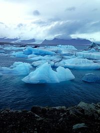 Scenic view of snow covered mountain against cloudy sky