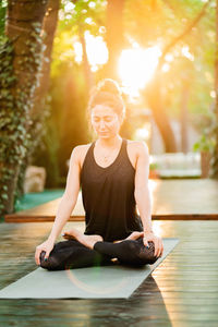 Woman exercising on mat at park